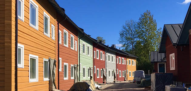 kaareva kaksikerroksinen rivitalo hirrestä Helsingissä